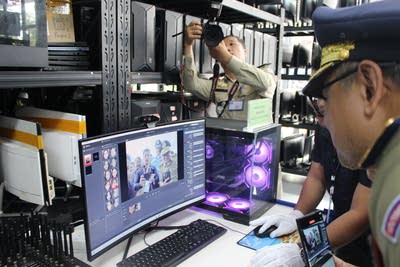 Police officers look at a computer screen