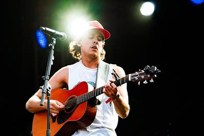 A musician plays guitar on an outdoor stage