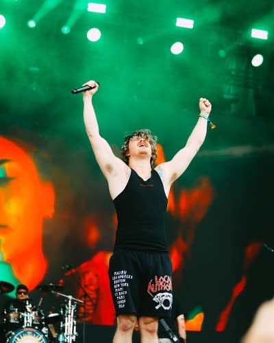 A musician strikes a triumphant pose onstage