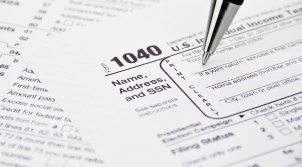 An IRS 1040 Tax form is filled out. 