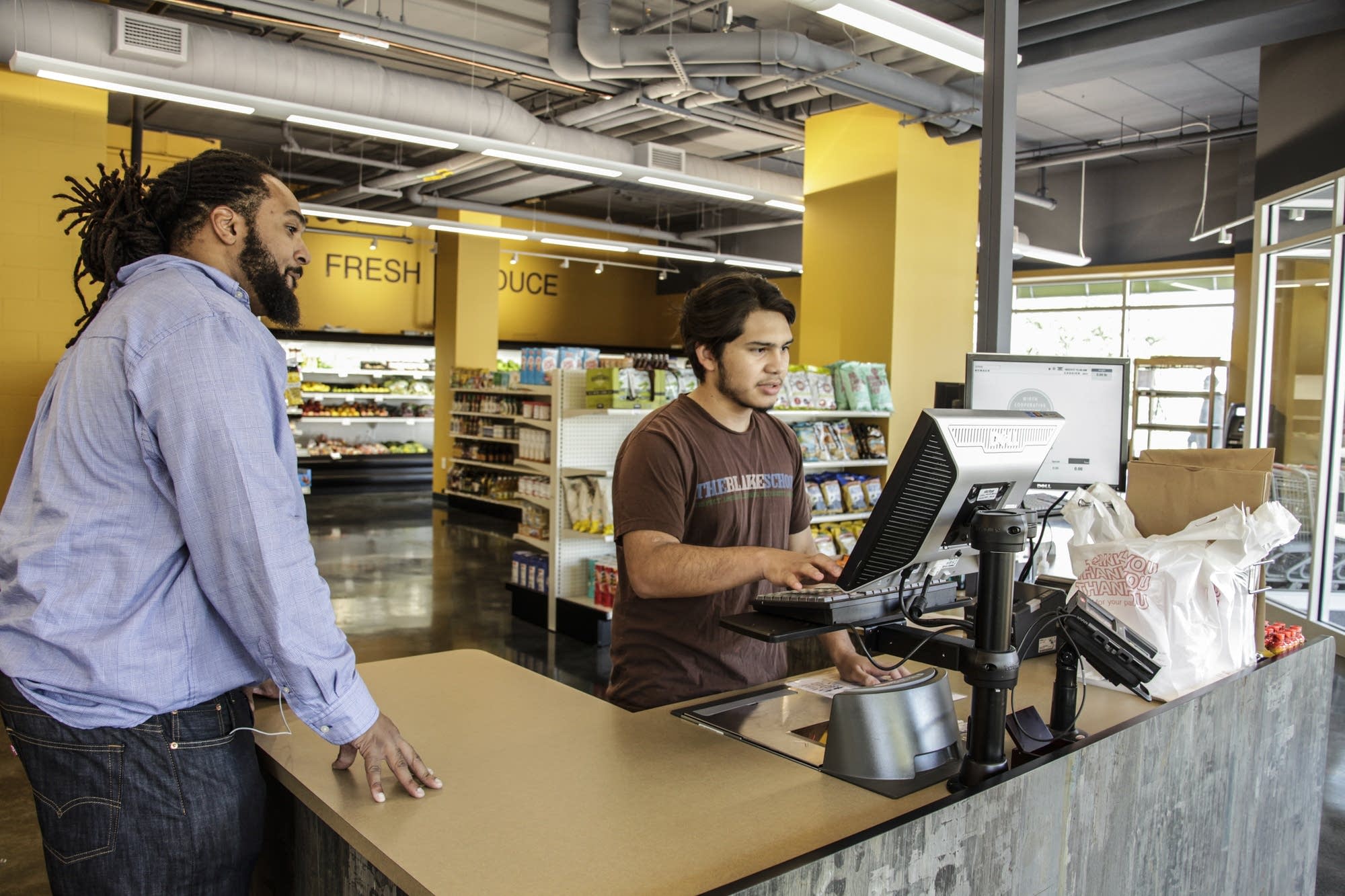 General Manager of Wirth Co-op Grocery, Winston Bell help his cashier.