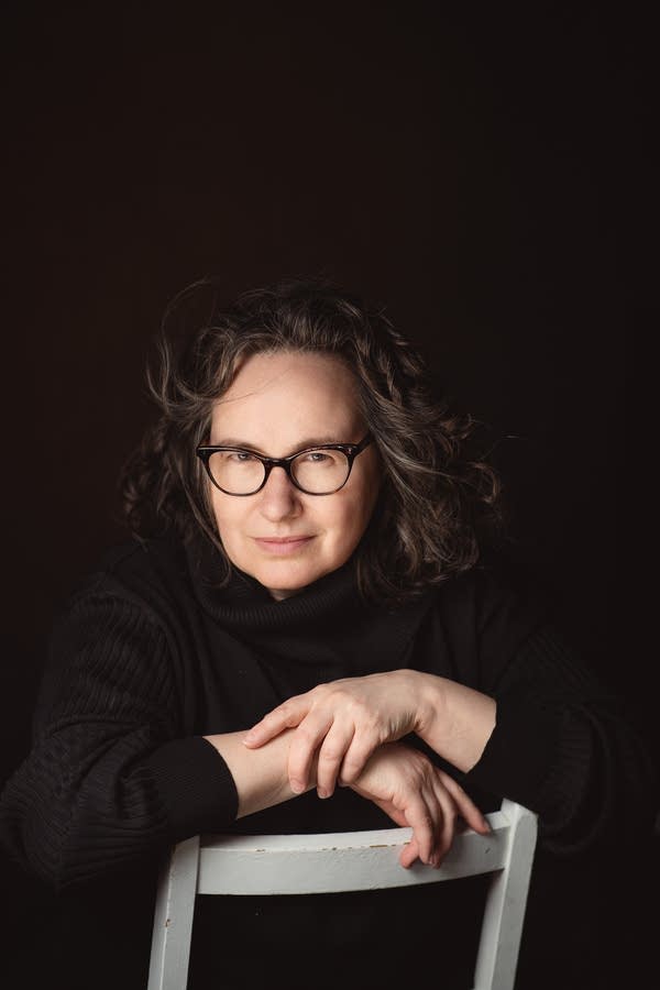 A woman sits on a chair for a portrait