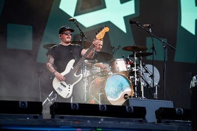 Two musicians performing on a large outdoor stage