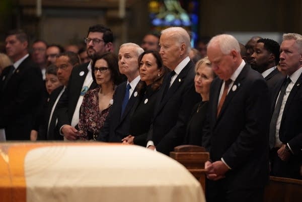 People stand in pews