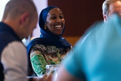 A woman laughs while at a group lunch.