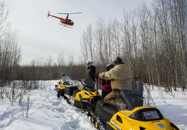 A helicopter leaves the site of a moose collaring.