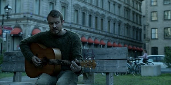 Screen shot from Amazon's Patriot showing John playing guitar