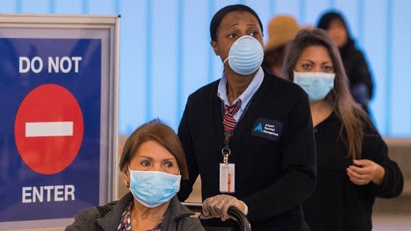 Passengers wear face masks to protect against COVID-19 after arriving at Los Angeles International Airport on March 5, 2020.