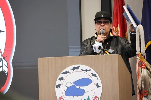 Man with hat speaking at podium