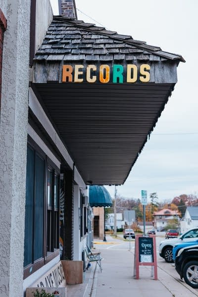 An awning extends from the facade of a record store on a commercial street