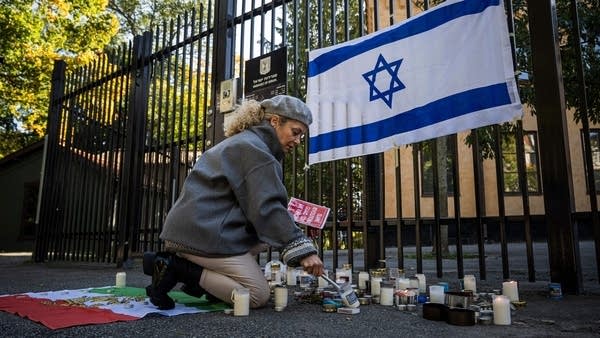 A woman lights a candle outside of the Israeli embassy in Stockholm on Monday. 