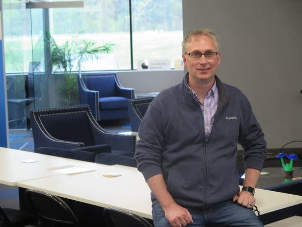 A man stands in front of a desk.