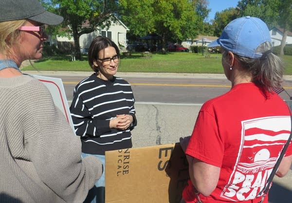 A woman speaks with protesters