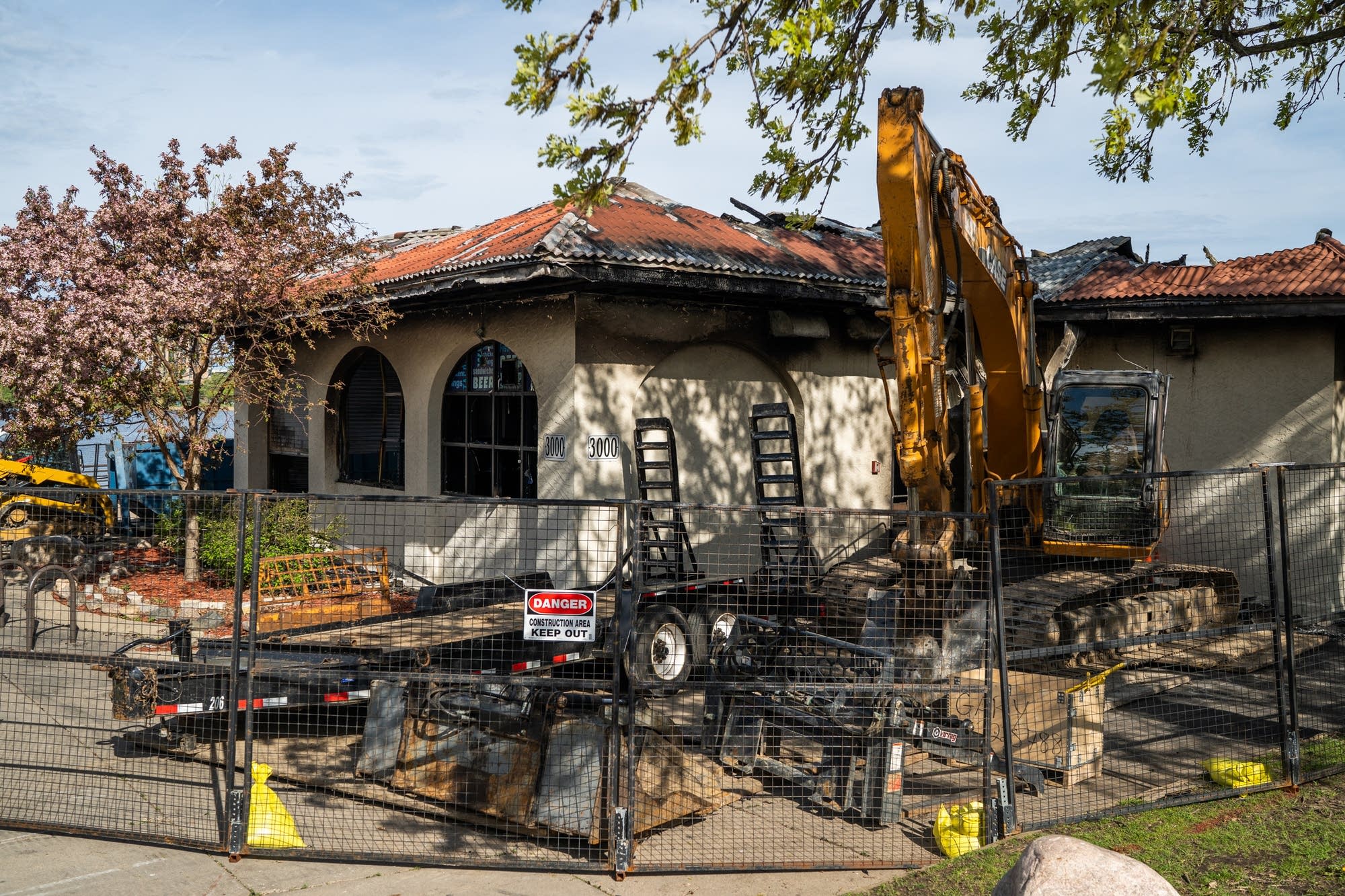 An excavator and other construction equipment sit outside.