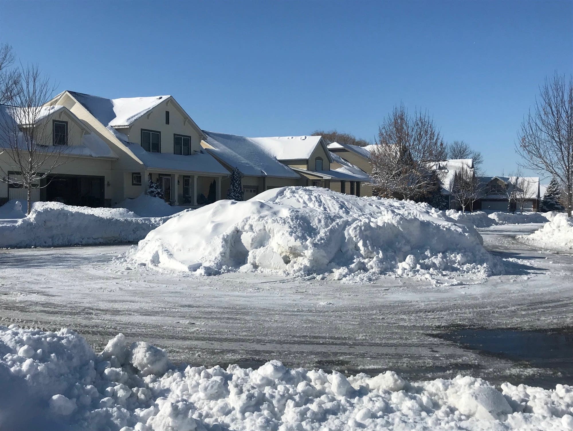 Massive piles of snow line a street in Chaska, Minn.