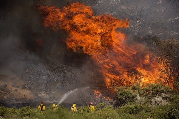 Firefighters work against the Apple Fire. 