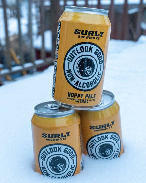 Three yellow cans of Surly beer.