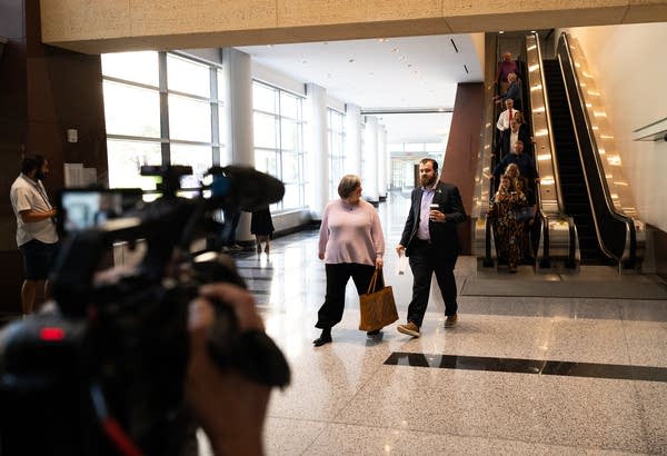 Two people walk through a courthouse lobby