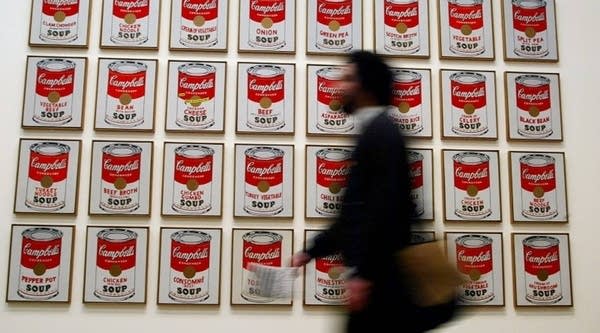  A spectator walks past Andy Warhol's "Campbells Soup Cans" at the 2002 Warhol retrospective exhibition  at the Tate Modern Gallery in London. 