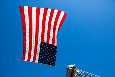 An American flag flies from two firetrucks.