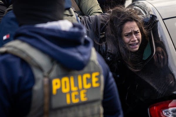 ICE agents detain a woman