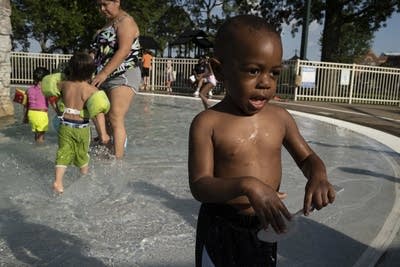 A boy plays in a wading pool.