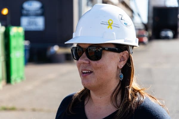 A woman wearing sunglasses and a white hard hate