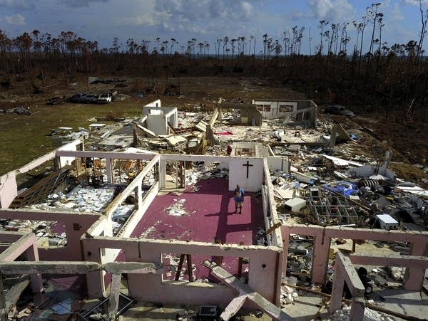 Pastor Jeremiah Saunders stands among the ruins of his church