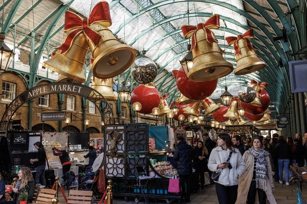 Venders prepare their stalls Friday under a Christmas display at Covent Garden's Apple Market in London.