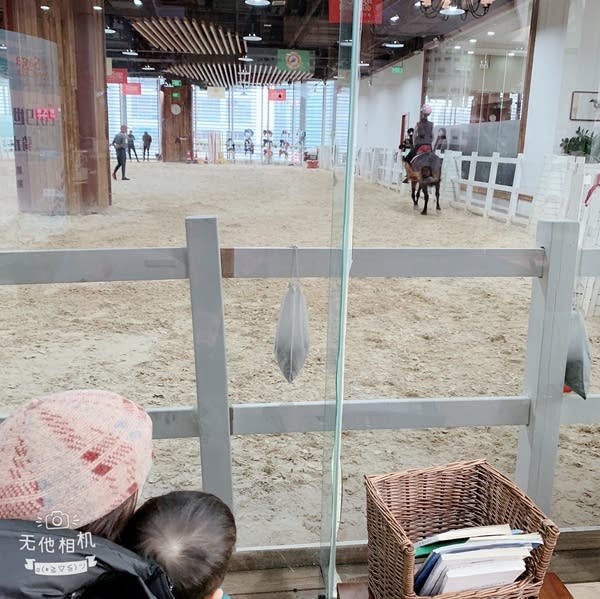 Harper Hsuan and her son, bottom left, observe a horse riding lesson in China.