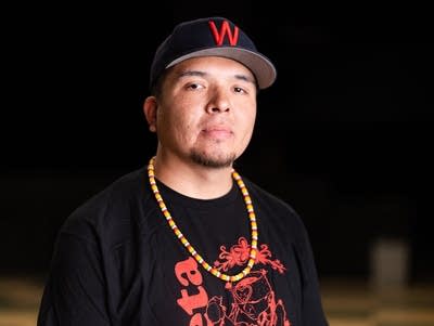 A man wearing a baseball cap and black T-shirt