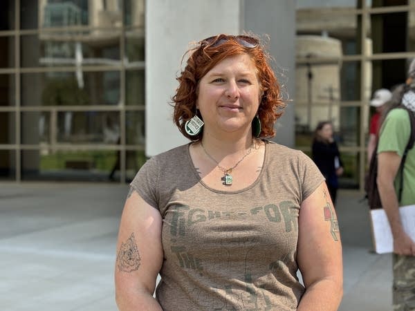 A woman poses for a photo outside an office building.