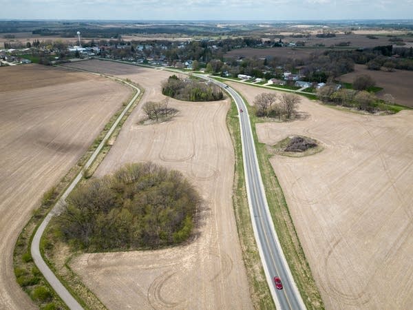 An aerial view of a highway and sinkholes dotting a field