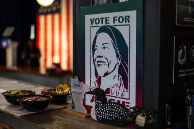 A campaign poster illustrating a woman's face leans against a post.