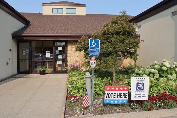 Signs sit outside of a building welcoming people in for voting.