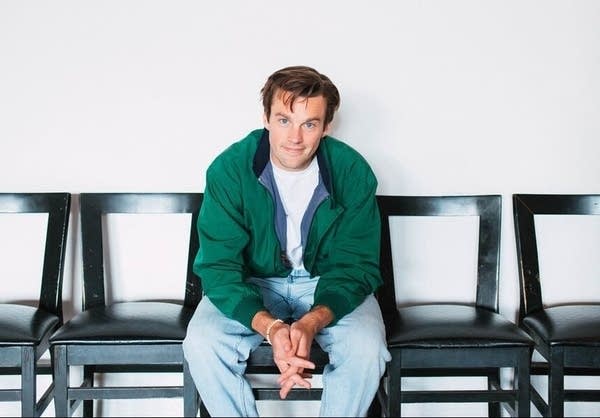 A man in a green jacket poses for a photo