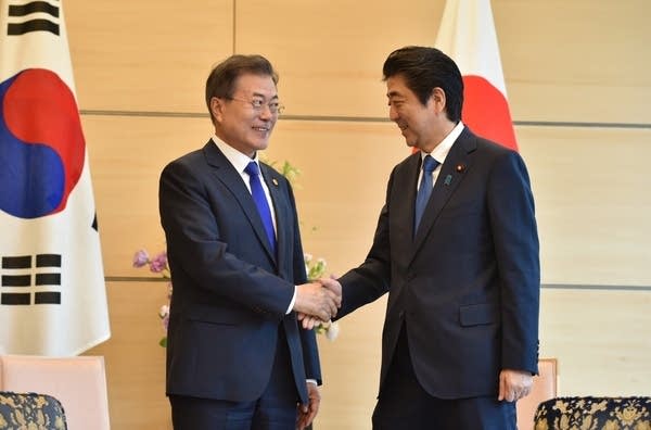 South Korea's President Moon Jae-in shakes hands with Japan's Prime Minister Shinzo Abe at a meeting in Tokyo last May. (Photo: KAZUHIRO NOGI/Anadolu Agency/Getty Images)