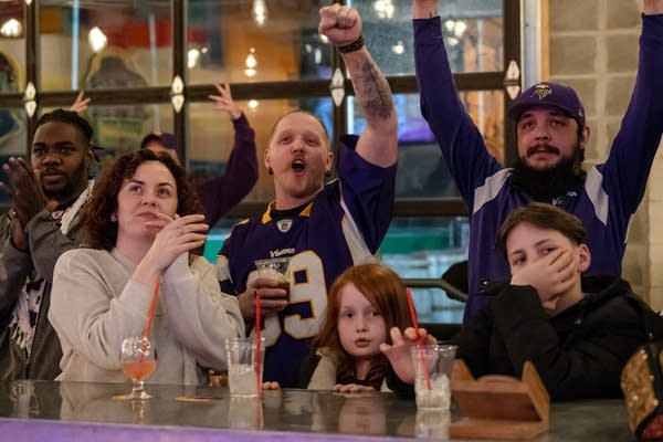 Fans cheer while watching the football game.
