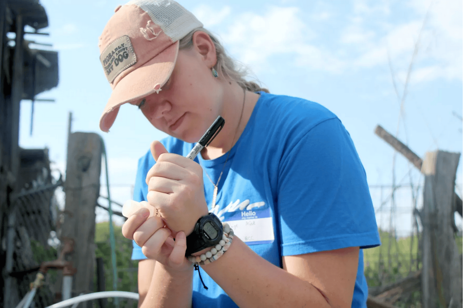 A person labeling a vial with a Sharpie
