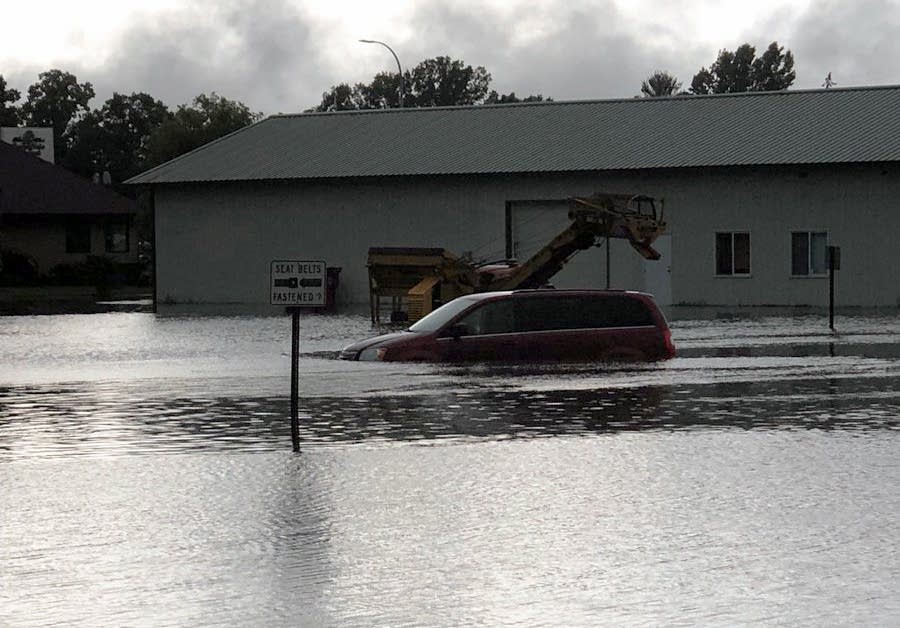 A car drives through a flooded road in Mora.