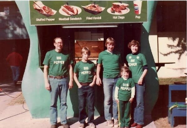Five people smile in front of a pepper