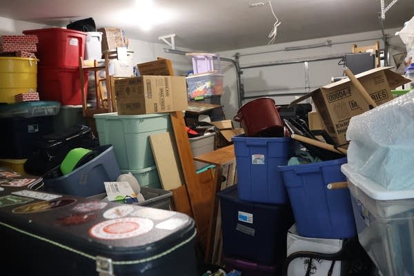 A garage is packed to the ceiling with tubs and boxes.