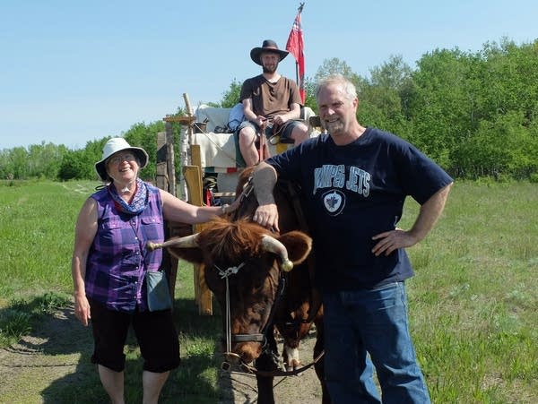 Three people with an ox and a wooden cart