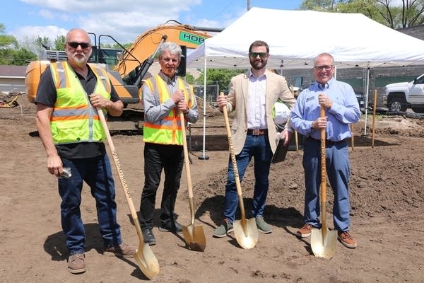 men stand with shovels
