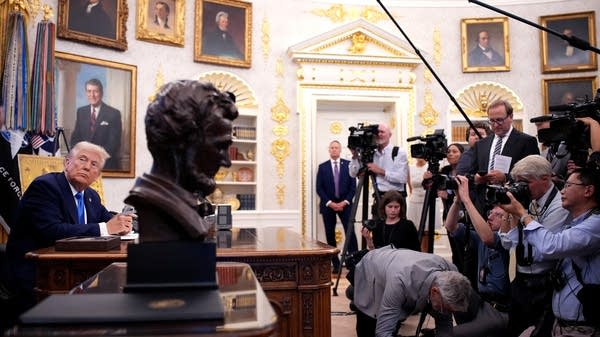 Trump signs executive orders in the Oval Office in front of press