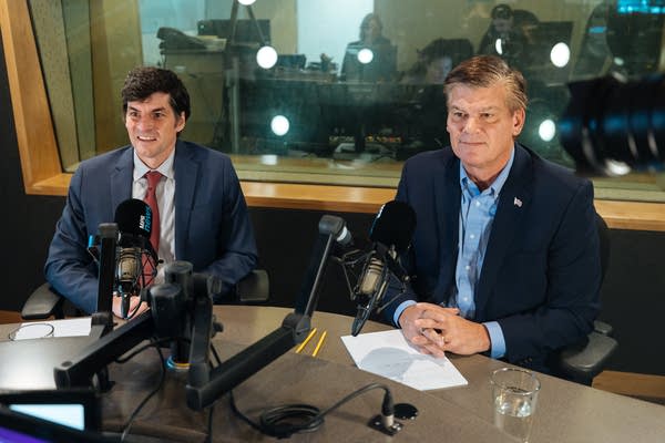 Two men sit inside a studio.
