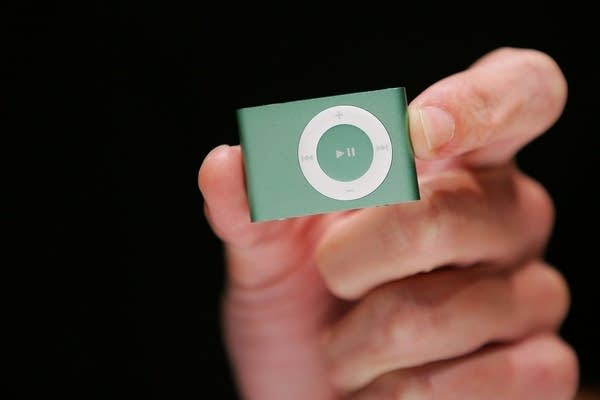 A hand holding an iPod Shuffle device in 2007