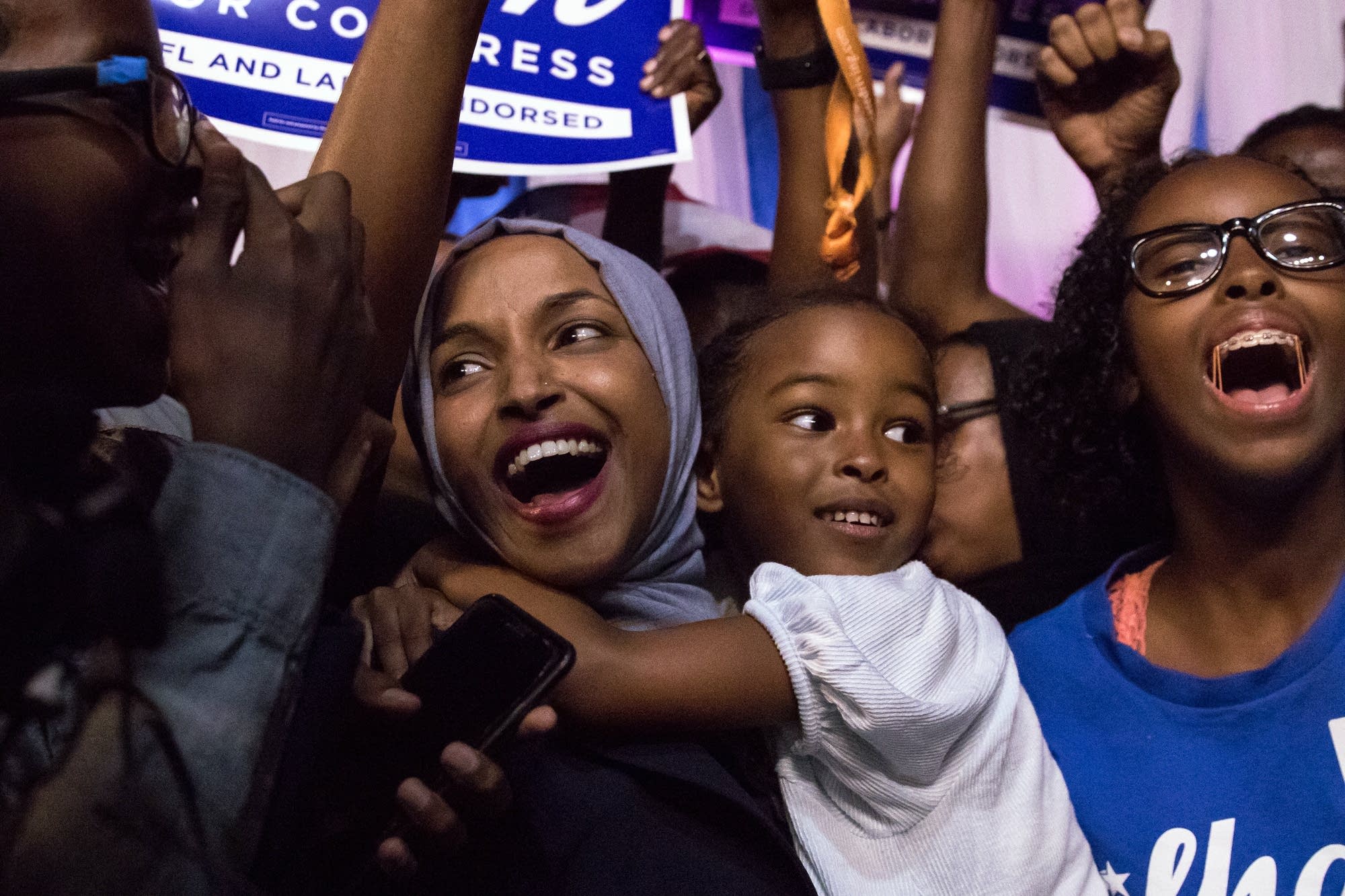 Ilhan Omar celebrates onstage with her children after her primary victory.