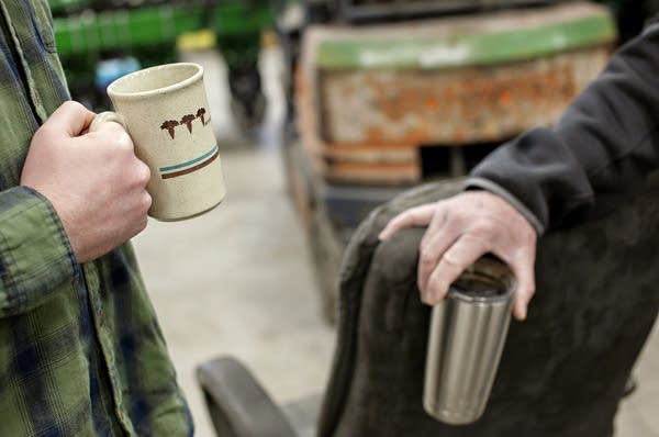 Two people hold coffee cups.