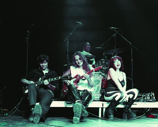 A rock band performing onstage in a music venue